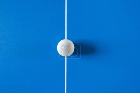 Foto de Una pelota de tenis blanca para un tenis de mesa en el fondo azul. - Imagen libre de derechos