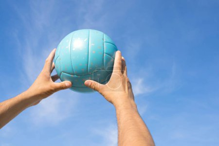 Téléchargez les photos : Une femme tient le volley dans ses mains. Fond bleu
. - en image libre de droit