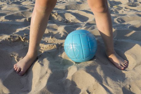 Photo for Cropped view of volleyball ball and child's feet on sand. - Royalty Free Image