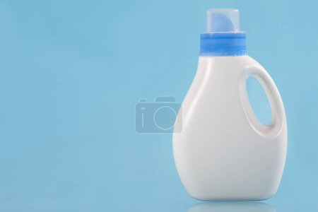 Foto de Botella con detergente sobre fondo azul. Copiar espacio. Concepto de limpieza. - Imagen libre de derechos