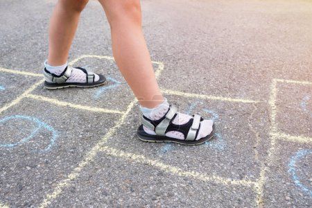 Photo for Children's feet and drawings with chalk on the pavement closeup. - Royalty Free Image