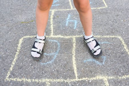Photo for Children's feet close-up on the pavement. View from above. Outdoor games. - Royalty Free Image