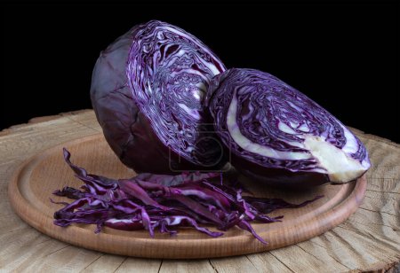 Shredded cabbage, red cabbage on wooden cutting board. Red cabbage on black background.