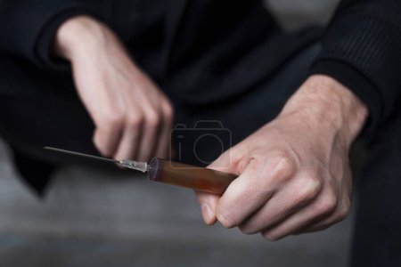Photo for Addict with a syringe in his hands, close-up. Addiction concept. - Royalty Free Image