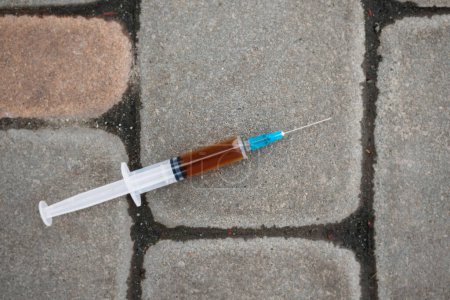 Photo for Used syringe on concrete, drug addiction - Royalty Free Image