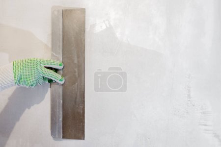 Foto de Mano sosteniendo una espátula. Herramientas, pared de yeso. Detalles de reparación. - Imagen libre de derechos