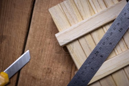 Téléchargez les photos : Outils de travail règle et couteau de papeterie sur une table en bois de travail. - en image libre de droit