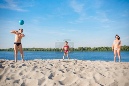 Téléchargez les photos : Jeu de sport volley-ball familial sur les rives de la rivière. Concept - jeux de sport. - en image libre de droit
