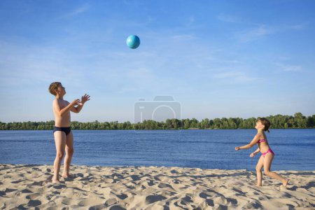 Téléchargez les photos : Beau frère et soeur jouent avec un ballon de plage en plein air
. - en image libre de droit