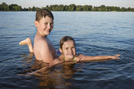 Foto de Niños felices jugando en el río, posando para la cámara. Estilo de vida saludable. - Imagen libre de derechos