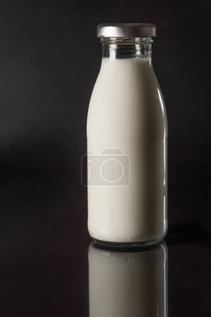 Téléchargez les photos : Bouteille de lait frais sur fond noir gros plan. Produits laitiers - en image libre de droit