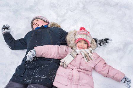 Téléchargez les photos : Les enfants jouent à l'extérieur en hiver. Vacances d'hiver. - en image libre de droit