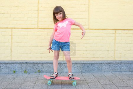 Téléchargez les photos : Moderne fille hipster urbaine avec un skateboard s'amuse en plein air. Sport, fitness, lifestyle. - en image libre de droit