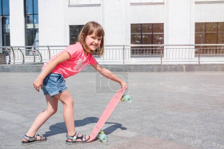 Téléchargez les photos : Happy girl apprend à patiner, en plein air. Sport, mode de vie. - en image libre de droit