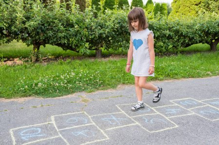 Photo for The child plays on the pavement in children's games. - Royalty Free Image