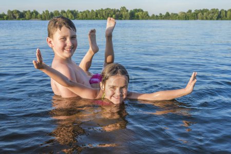 Foto de Niños felices juegan en el agua. Vacaciones de verano, estilo de vida activo. - Imagen libre de derechos
