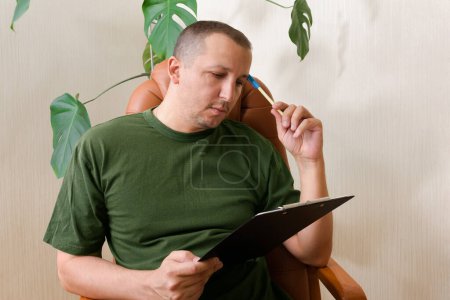 Foto de Hombre que sufre de depresión con un portapapeles en una recepción con un psicólogo. Concepto de salud mental. - Imagen libre de derechos