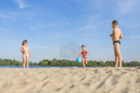 Téléchargez les photos : Bonne famille joue au beach-volley. Mode de vie sain. - en image libre de droit