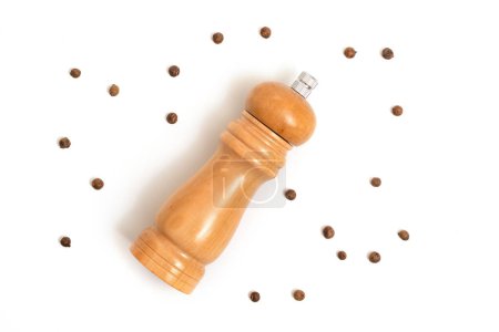 Photo for Wooden pepper mill and peppercorns isolated on white background. Cooking concept, top view. - Royalty Free Image