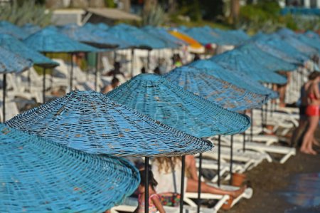 Téléchargez les photos : Parasols en osier de couleur bleue sur la plage. - en image libre de droit