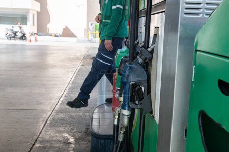 Foto de Un empleado de gasolinera repostando un coche. - Imagen libre de derechos