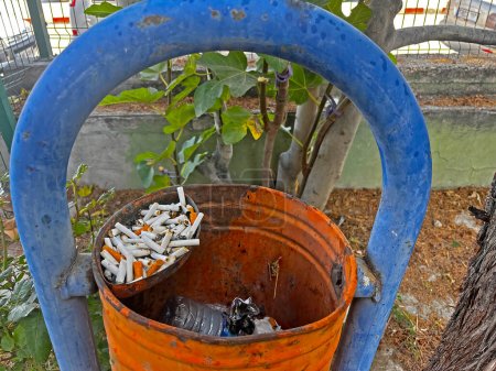 Photo for Old trash can with cigarette butts in it. - Royalty Free Image