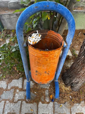 Foto de Viejo bote de basura con colillas de cigarrillo en él. - Imagen libre de derechos