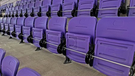 Téléchargez les photos : Sièges pour spectateurs violets dans la salle de sport intérieure. - en image libre de droit