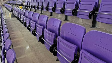 Téléchargez les photos : Sièges pour spectateurs violets dans la salle de sport intérieure. - en image libre de droit