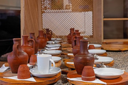 Téléchargez les photos : Café de cumin noir turc préparé pour être servi sur la table et pots d'eau en terre cuite à côté. - en image libre de droit