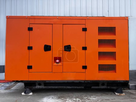 Orangefarbener Generator am Rande eines Arbeitsplatzes.