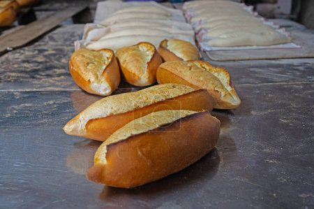 Photo for Freshly baked breads in the oven and and doughs in the background. - Royalty Free Image