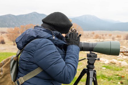 Vogelbeobachtung mit dem Teleskop am See bei kaltem Wetter.