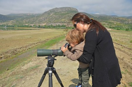 Der Junge betrachtet Vögel durch ein Teleskop.