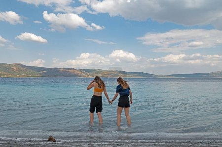 Photo for Young girls walking on Salda Lake. Young girls walking on the lake. - Royalty Free Image