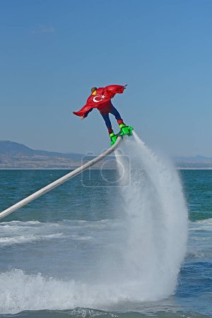 The guy flyboarding on the lake.