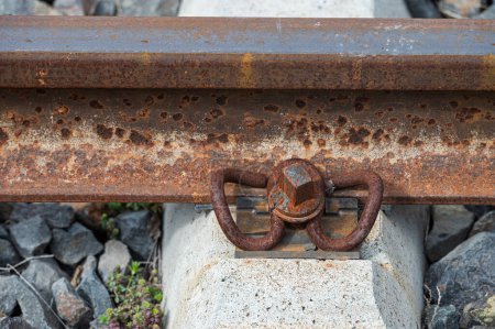 Aparato de conexión de hierro que conecta el carril con el durmiente en el ferrocarril. Soporte oxidado para vías férreas.