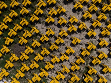 Luftaufnahme des Lagerbereichs gelb gefärbter Ballenpressen aus einer Fabrik.
