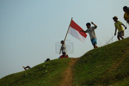 Téléchargez les photos : Un groupe d'enfants qui tirent de la guerre. Cette tradition est souvent réalisée comme un concours pour commémorer la fête de l'indépendance indonésienne le 17 août tangerang, 06 août 2023. - en image libre de droit