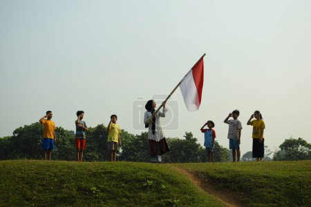 Téléchargez les photos : Enfants montrant du respect pour le drapeau rouge et blanc, le drapeau national indonésien en commémoration du 78e jour de l'indépendance de l'Indonésie 17 août.tangerang, 6 août 2023. - en image libre de droit