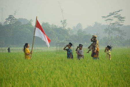 Téléchargez les photos : Enfants montrant du respect pour le drapeau rouge et blanc, le drapeau national indonésien en commémoration du 78e jour de l'indépendance de l'Indonésie 17 août.tangerang, 6 août 2023. - en image libre de droit