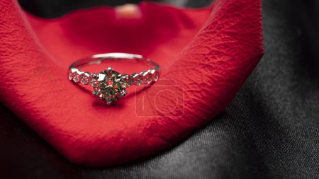 schöner Diamantring auf einem roten Rosenblatt