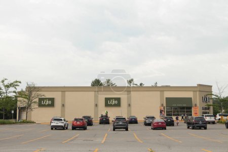 Photo for Lcbo liquor control board of ontario logos side of building and front entrance, parking lot with cars parked, wide shot, building bottom frame - Royalty Free Image