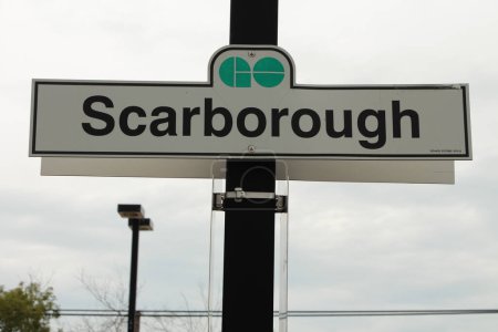 Téléchargez les photos : Aller train transit système de transport en commun scarborough signe avec logo vert sur fond blanc fixé au poteau avec haut de clôture liée au diamant en bas de l'avant-plan - en image libre de droit