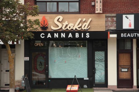 Photo for Stokd cannabis retail store dispensary front entrance with sidewalk in front, open sign, opaque windows - Royalty Free Image