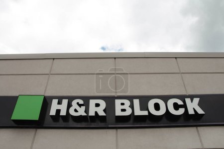 Foto de Logotipo de bloque h y r en la entrada frontal de la pequeña tienda, disparado desde un ángulo bajo mirando hacia arriba con el cielo en el fondo, verde blanco y negro - Imagen libre de derechos