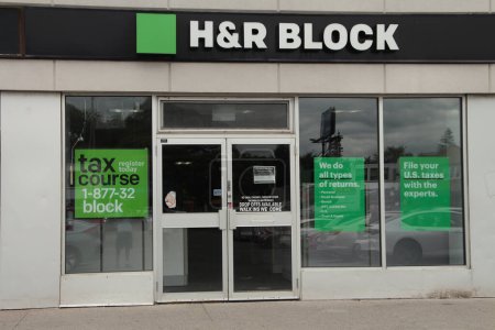 Téléchargez les photos : Logo h et r bloc sur l'entrée avant du petit magasin, prise de vue à angle bas regardant vers le haut avec le ciel en arrière-plan, vert blanc et noir - en image libre de droit