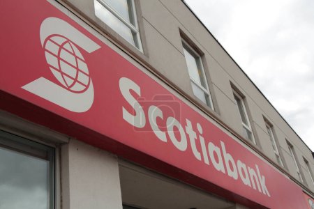 Photo for Scotiabank caption writing text logo on front entrance of store with windows and sky above, white writing on red background - Royalty Free Image