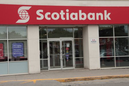 Photo for Scotiabank storefront, caption writing text logo on front entrance of store with windows, white writing on red background, close up - Royalty Free Image