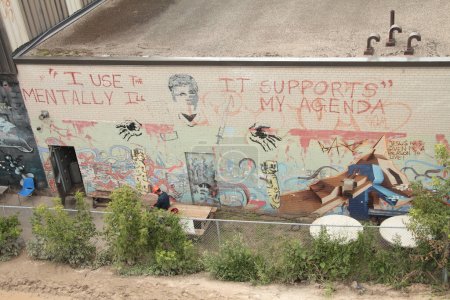 Foto de Uso los enfermos mentales apoya mi agenda escrito texto de leyenda en la construcción de mural de pared con trabajador en sombrero de construcción naranja sentado en descanso en frente - Imagen libre de derechos